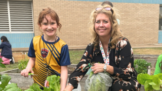  Green Squad sponsor and student harvesting lettuce